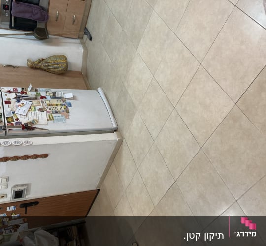 מטאטא ומגב מונחים על ארון במטבח